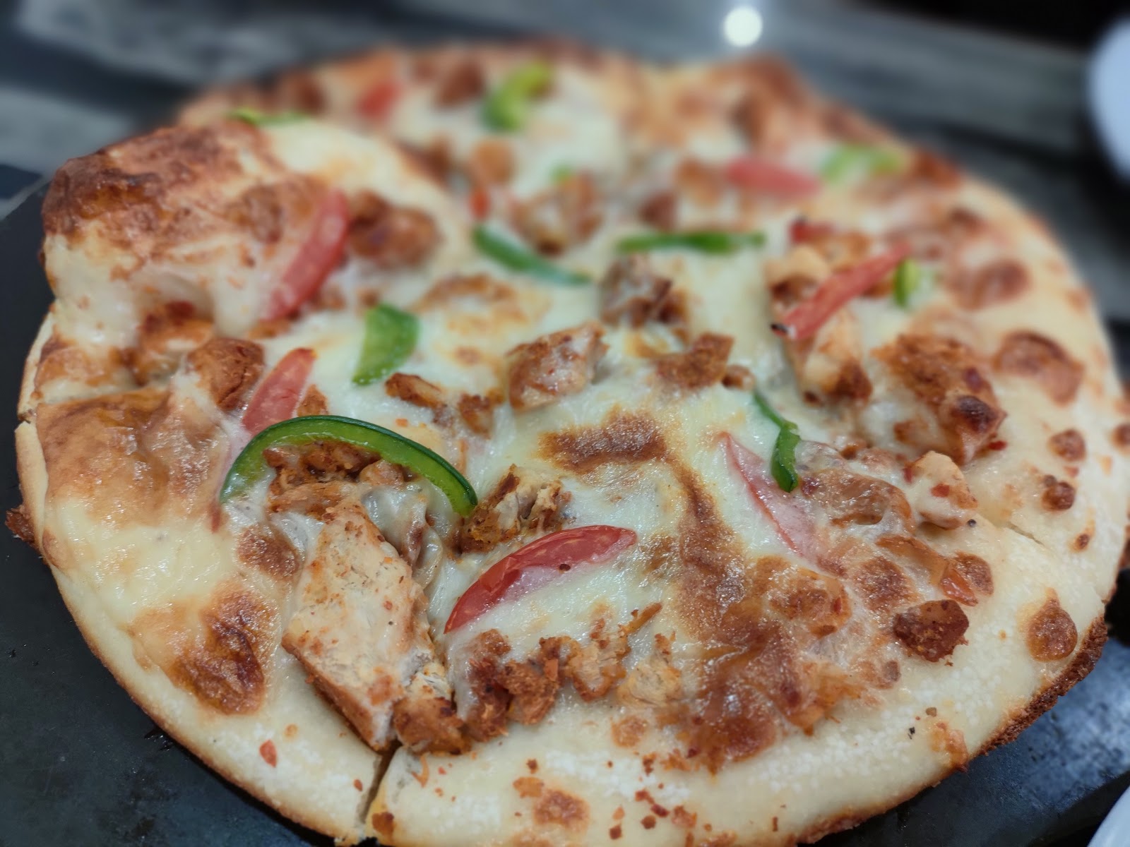 Chicken tikka pizza with peppers and tomato