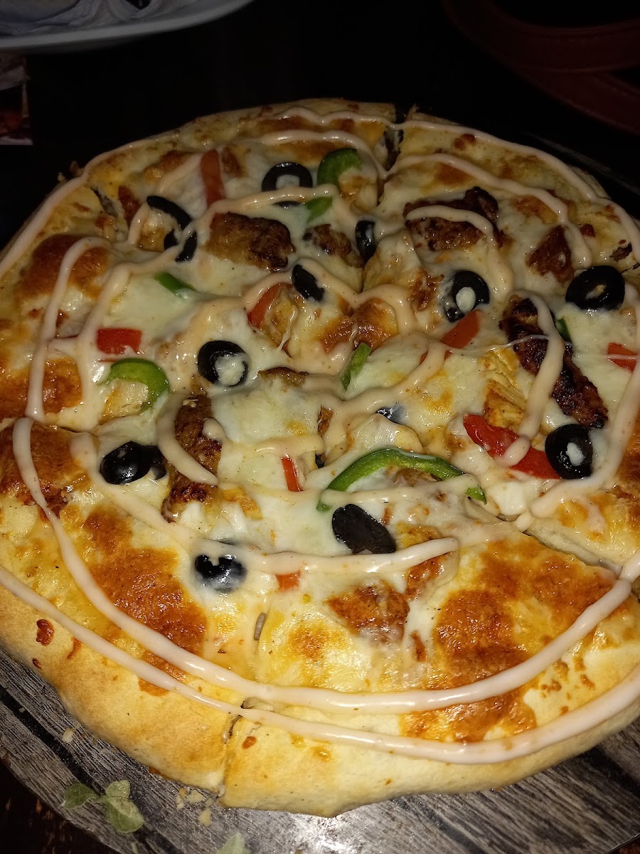 Pizza with olives, peppers and sauce drizzle